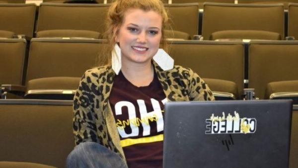 Female student sits with laptop